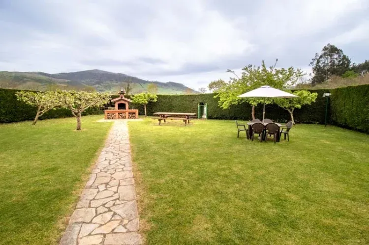 Imagen de Zona de barbacoa y de descanso en el jardín.