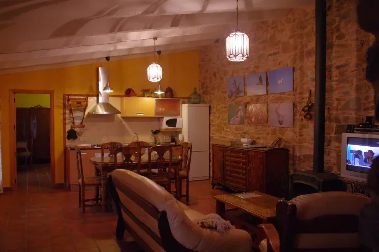 Imagen de Salón con hogar de leña y cocina