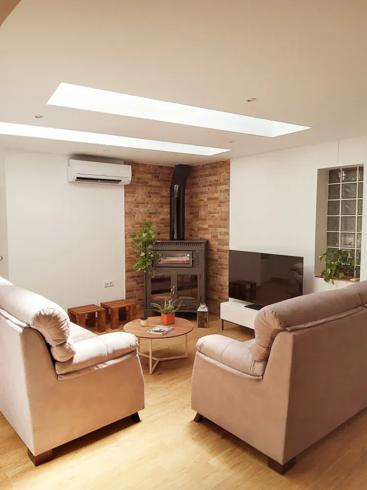 Imagen de Salón principal con chimenea y horno de leña.