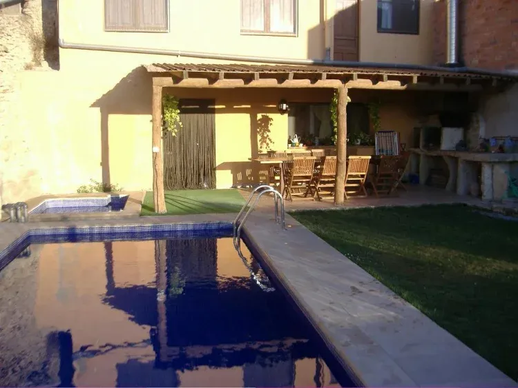 Imagen de Detall porxe al costat de la barbacoa, gespa i piscina.