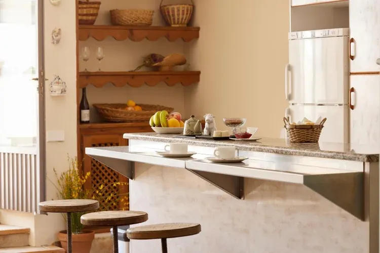 Imagen de La cocina cuenta con sillas de bar y una barra